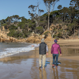 Two people walking on a Bundian Way beach