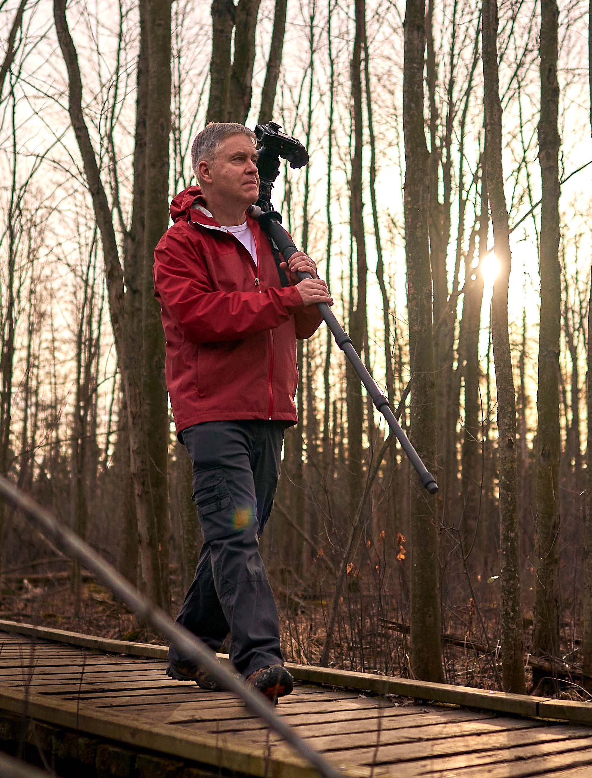 Bill Boswell in park walking with camera photo