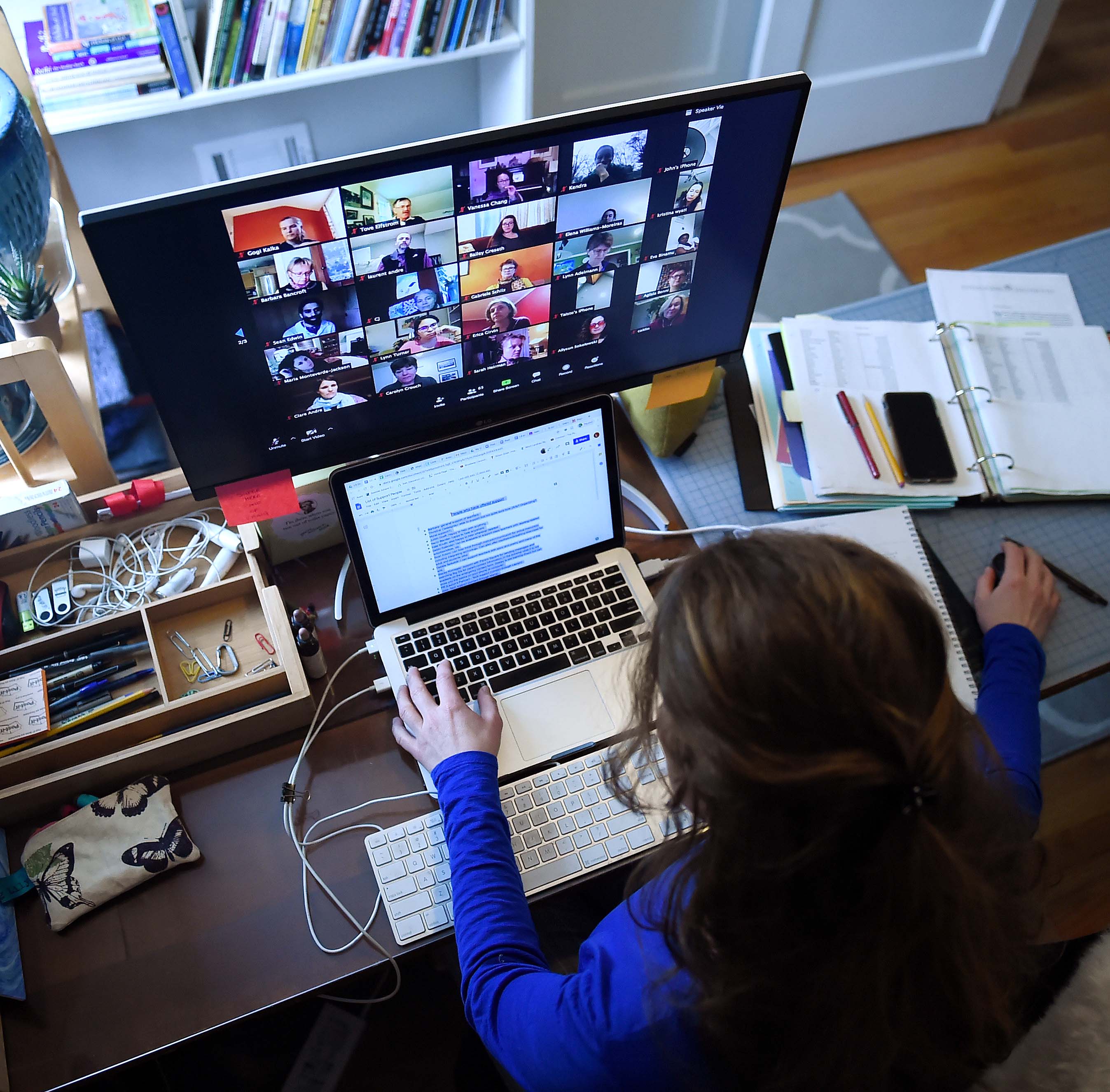 Woman in front of laptop and large display with keyboard