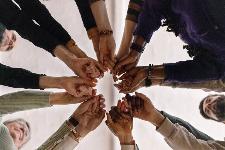 Group putting hands together in circle
