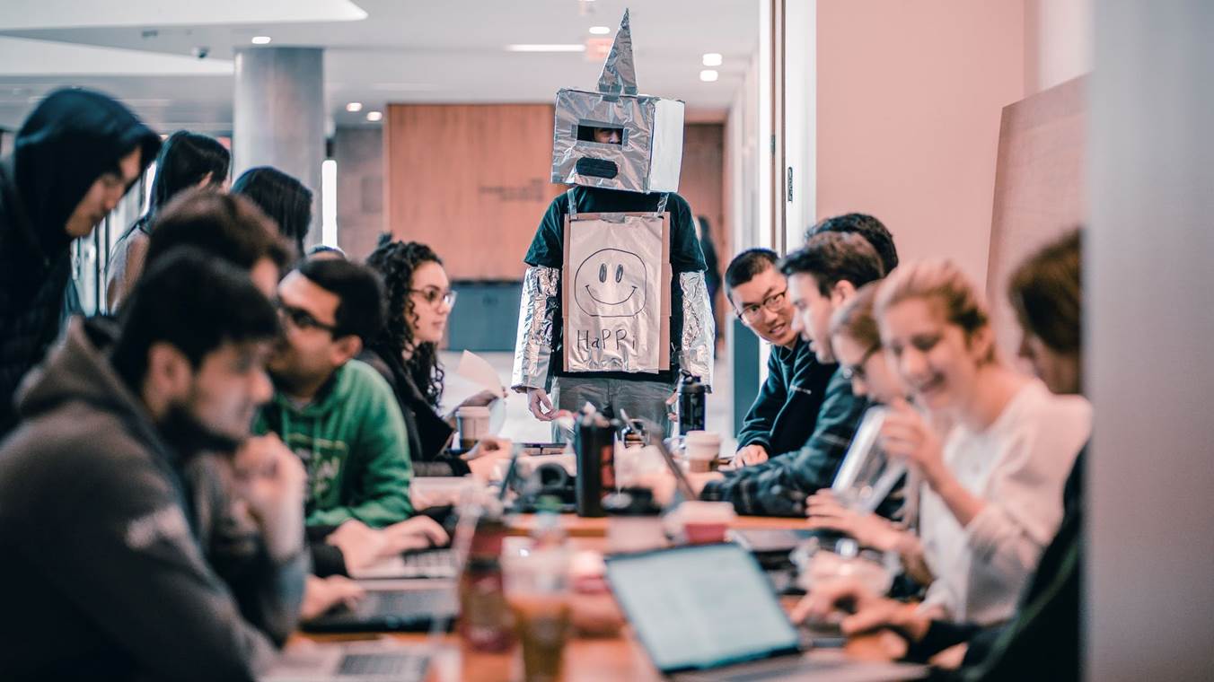 Students Studying With One Of Them Dressed In A Robot Suit