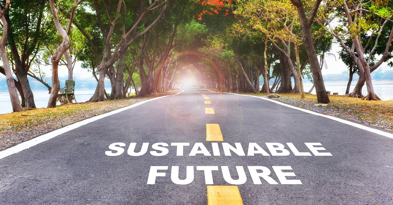 Sustainable Future written on road leading through trees