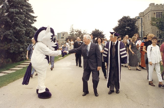Richard M. Ivey shaking hands with Western University’s mascot, JW, at Ivey’s 75th anniversary celebration in 1997