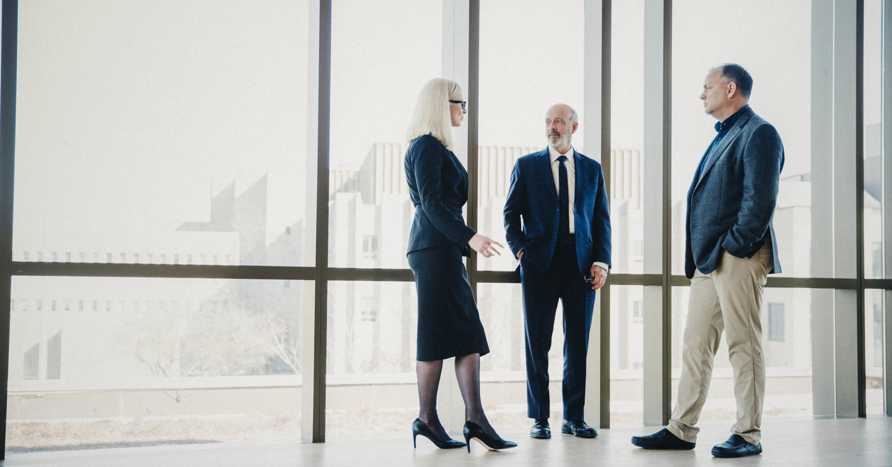 Group of business people standing by an office window