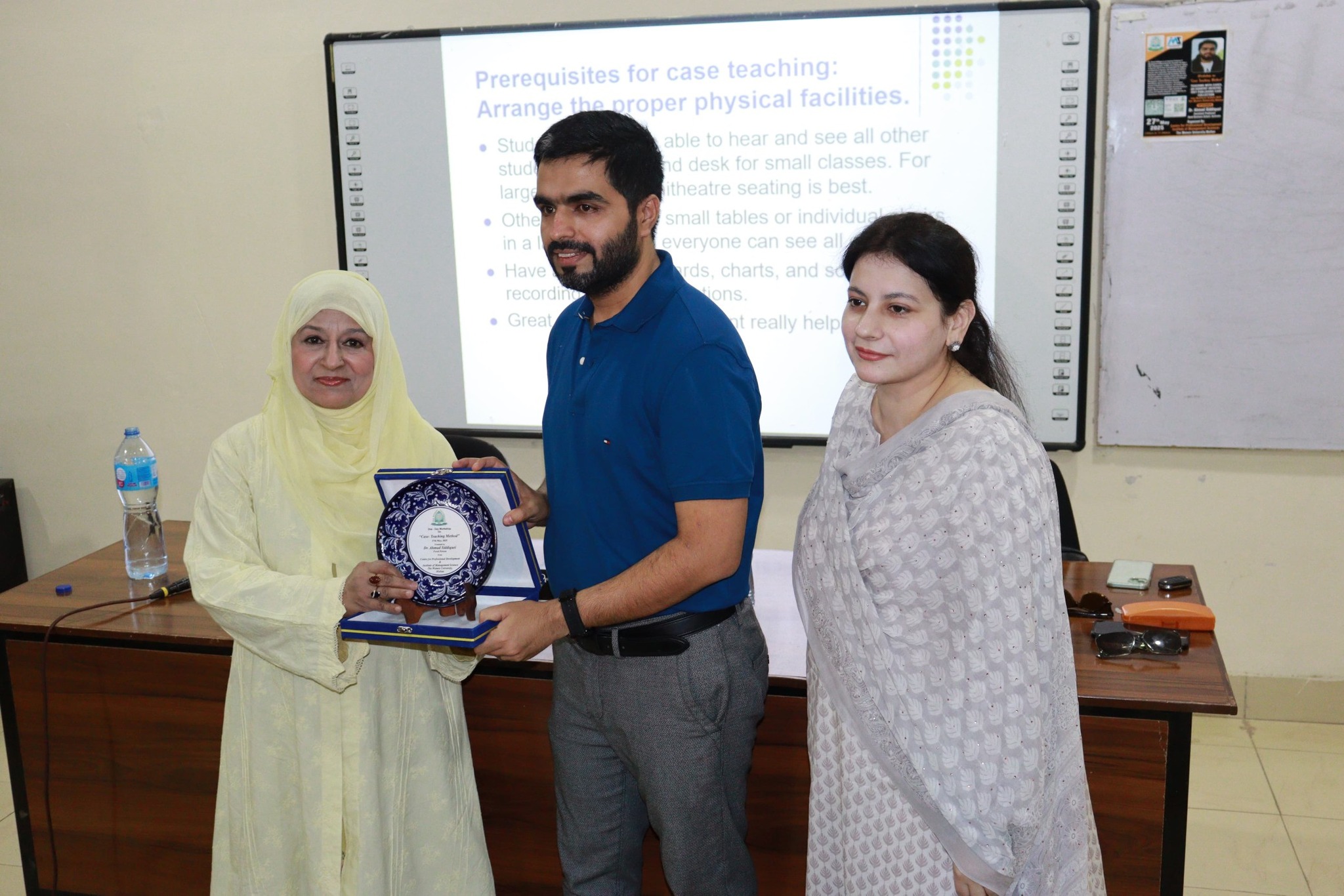 Professor Siddiquei at Women University Multan receiving a gift