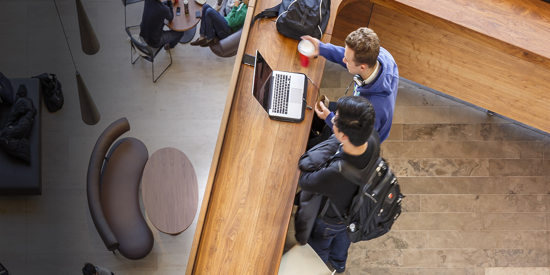 Two students having a discussion while looking at a laptop at the Ivey Business School