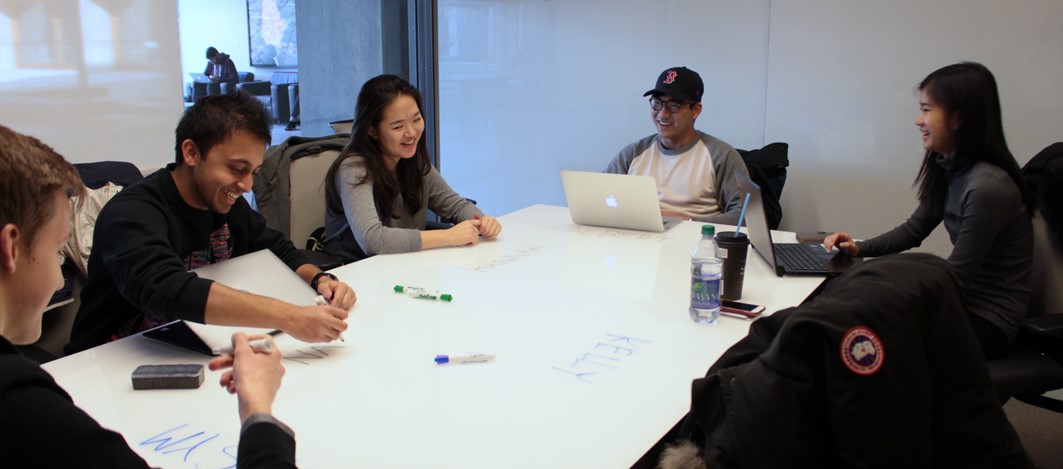 Students laughing while brainstorming together at a table