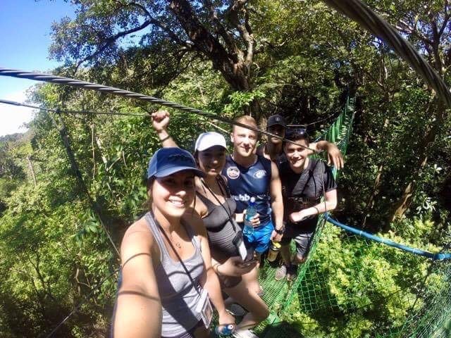 A group of students on a hanging bridge in the jungle