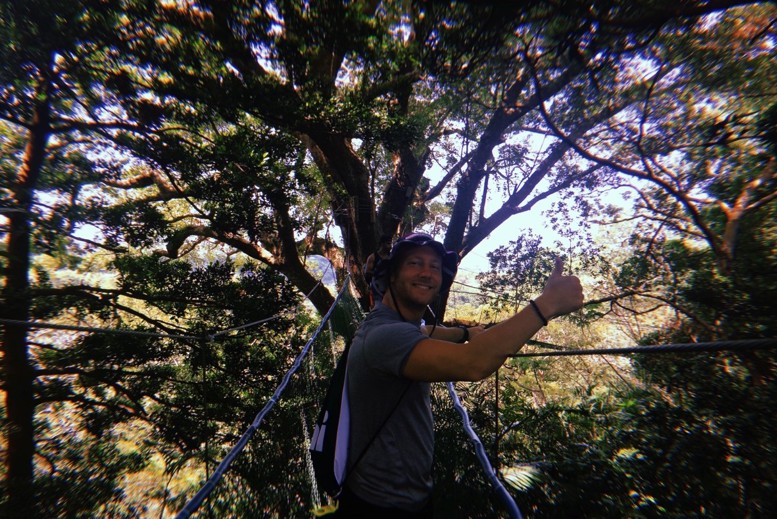 A man giving the thumbs up on a hanging bridge
