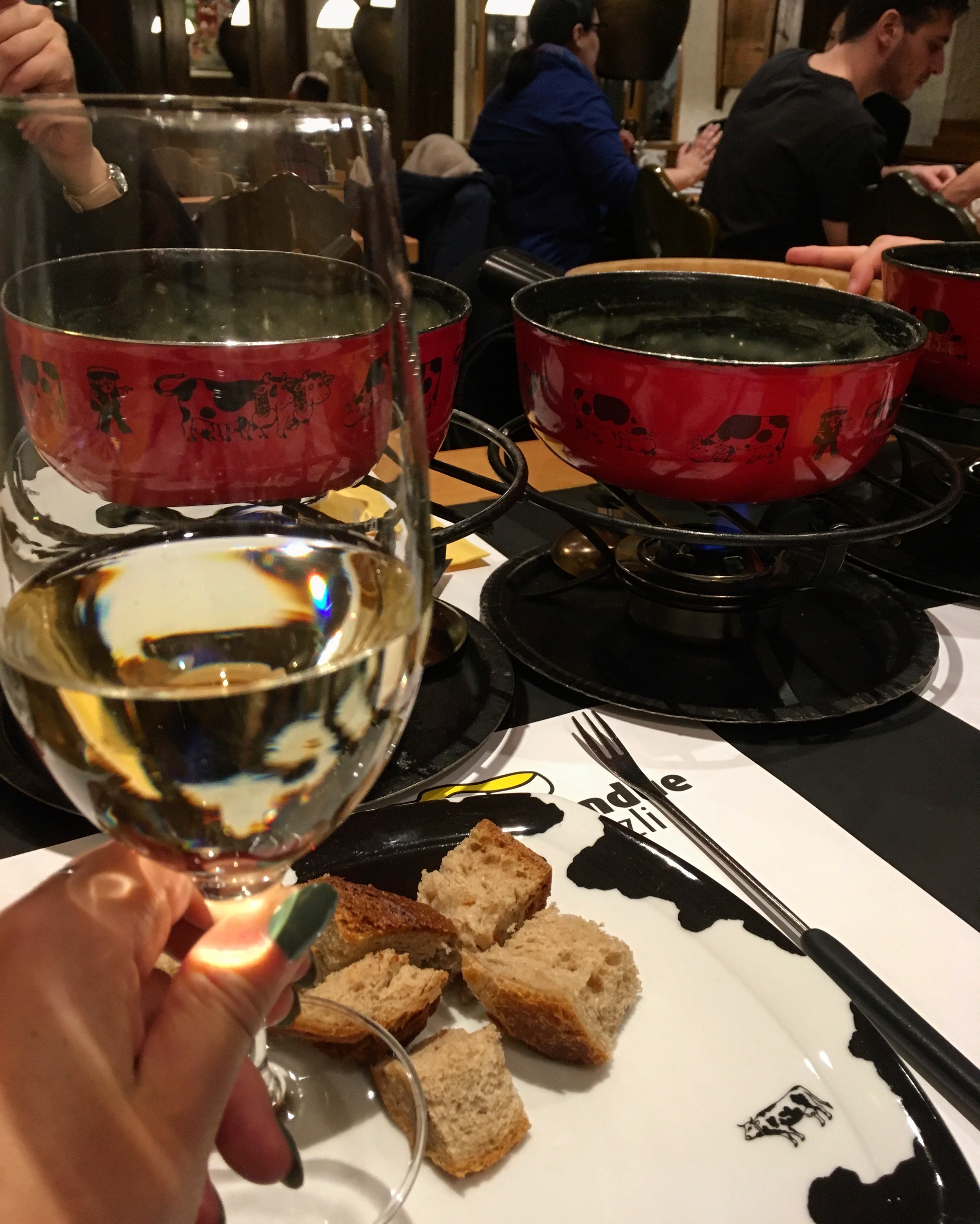 A woman looking at her wine glass and food, St. Gallen, Switzerland