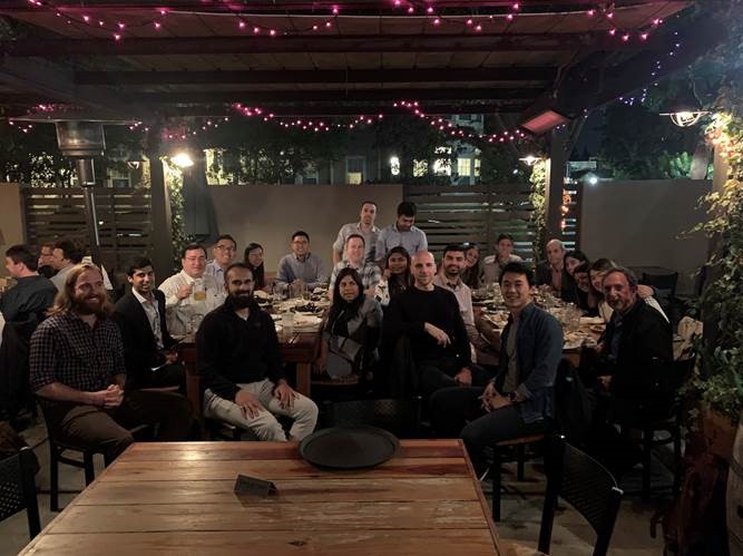 A group of people sitting at a table at the event smiling for the picture