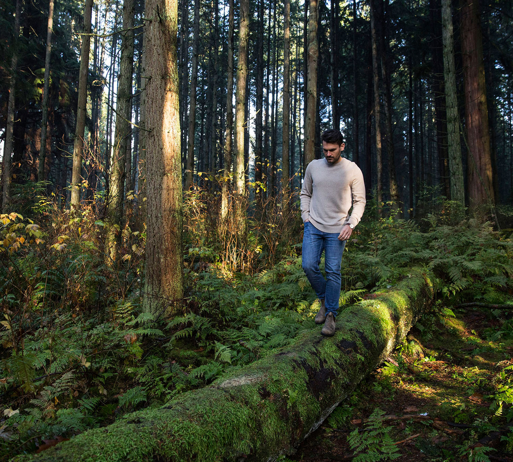 Image of Derrick Emsley walking on a log in the forest