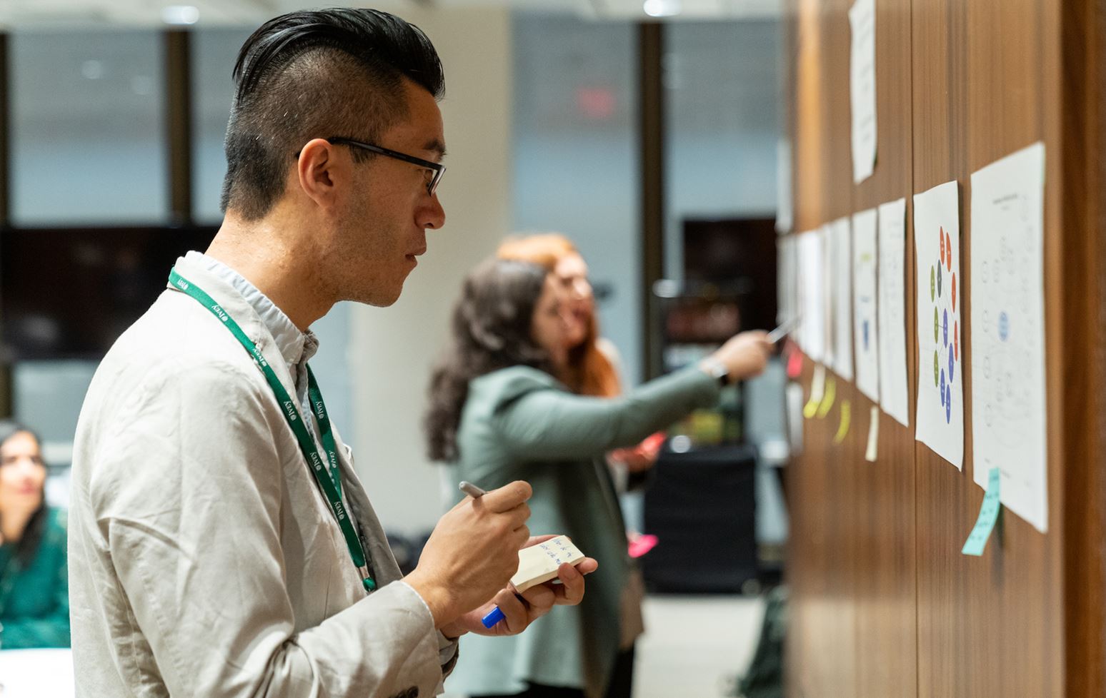 Student making notes while looking at a poster