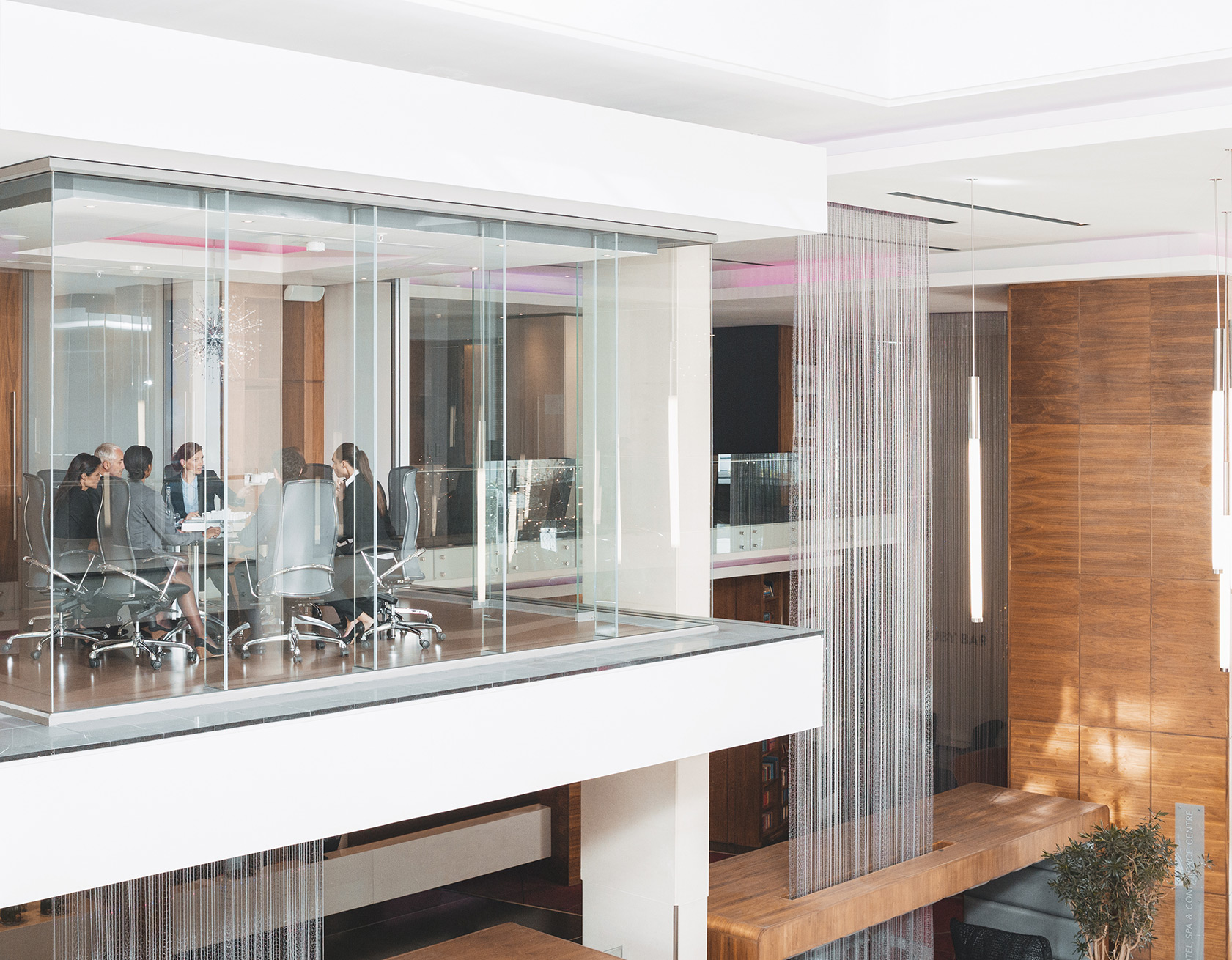 A group of executives in a glass-enclosed room