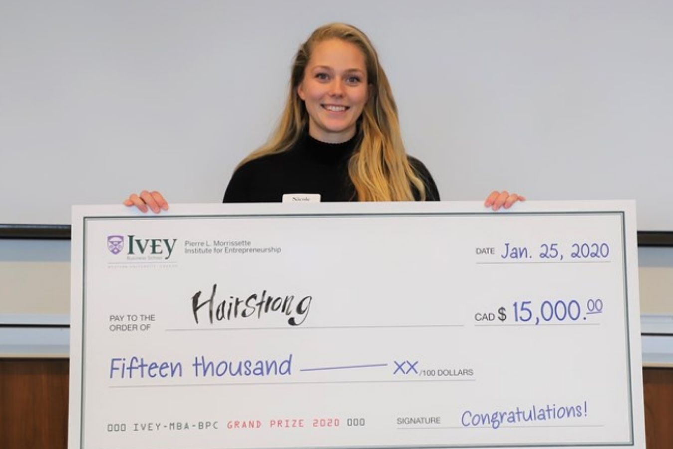 Hairstrong Founder Holding Winning Cheque For 2020 Business Plan Competition