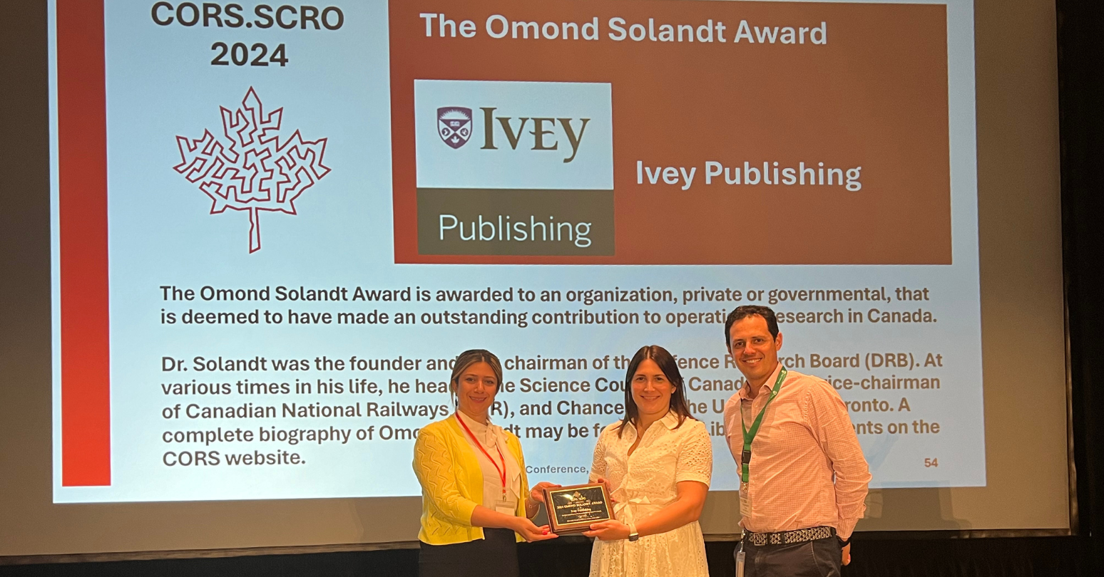 Violetta Gallagher (centre) and Alejandro Garcia (right) receiving the Omond Solandt Award at the Canadian Operational Research Society Conference banquet.