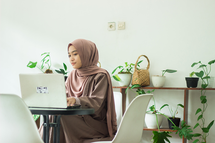 Female Muslim student on laptop