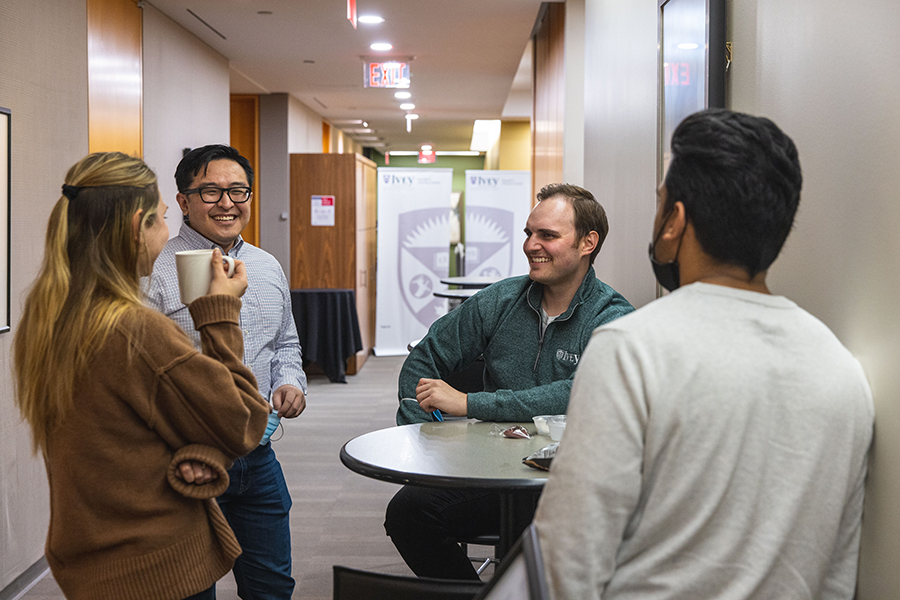 Students standing around a table engaged in conversation