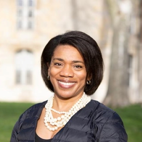 Felicia A. Henderson, Contributing Practitioner Scholar, smiling outdoors in front of a stone building.
