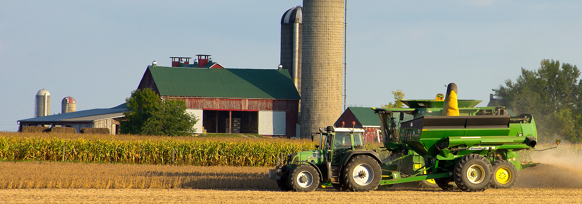 A John Deer combine harvesting a field of soy beans on a clear fall day in Southwestern Ontario, Canada.