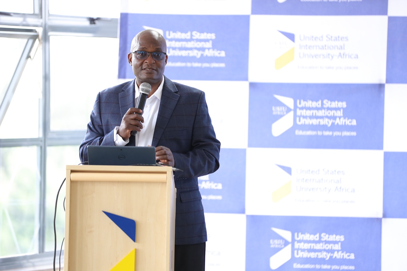 The Dean holds a microphone