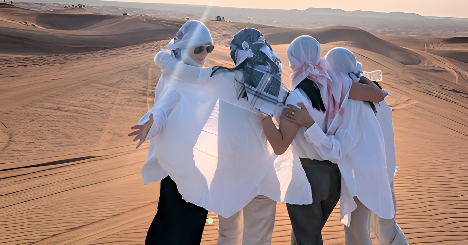 A group of Ivey MBA students posing on the sand dunes in the desert