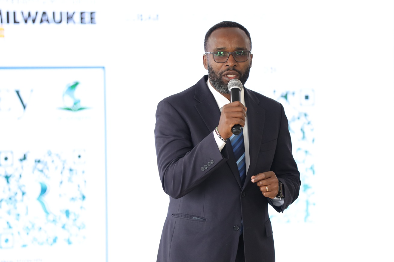 A man hold a microphone and speaks to the audience.