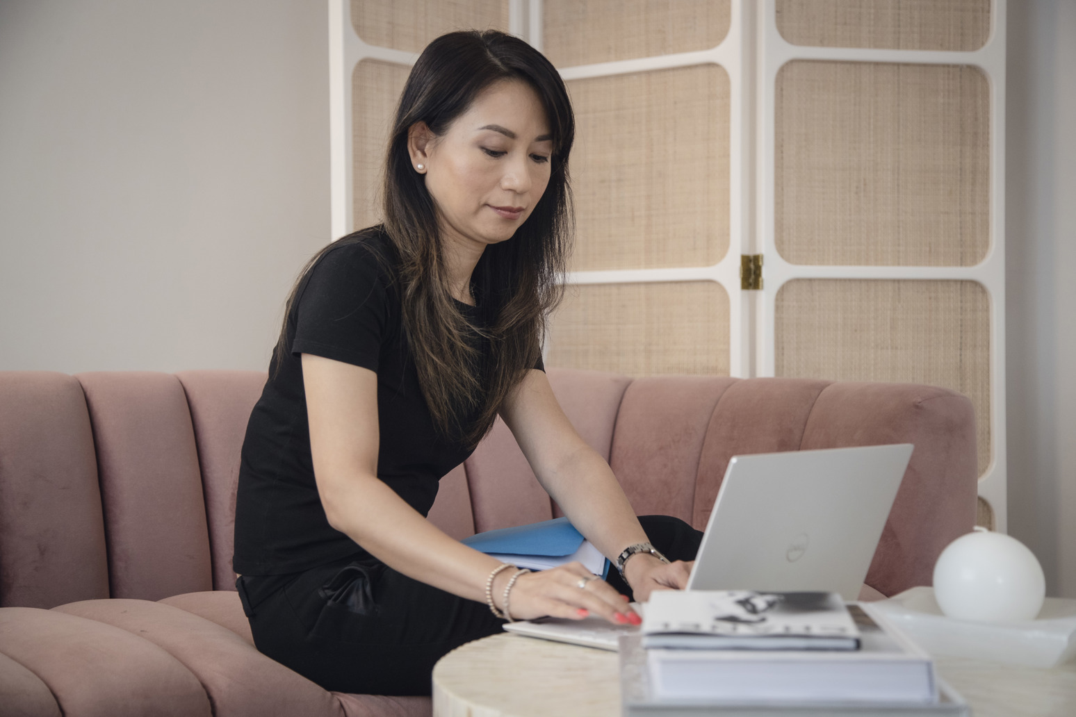 An Asian woman typing on a laptop