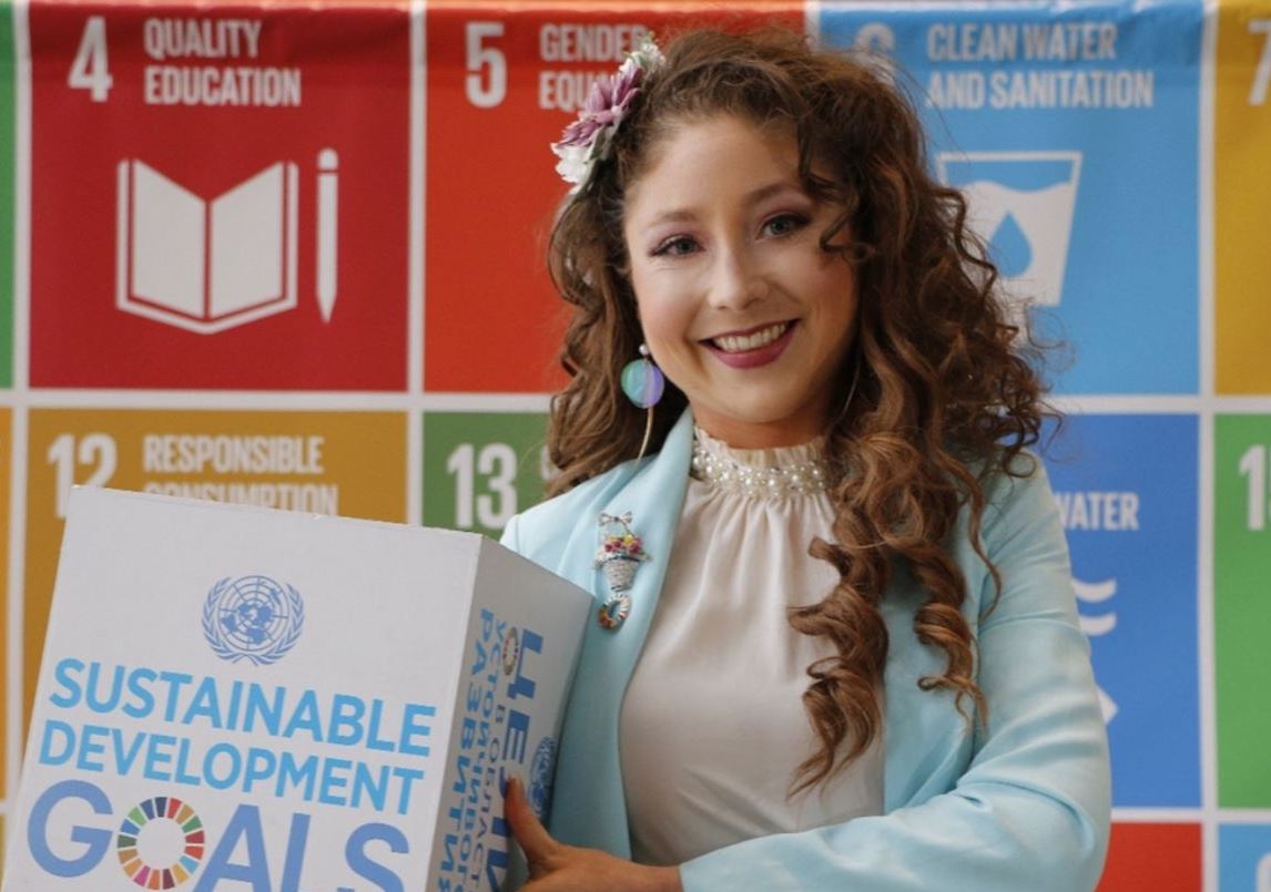 Alumna holding Sustainable Development Goals cube at an event