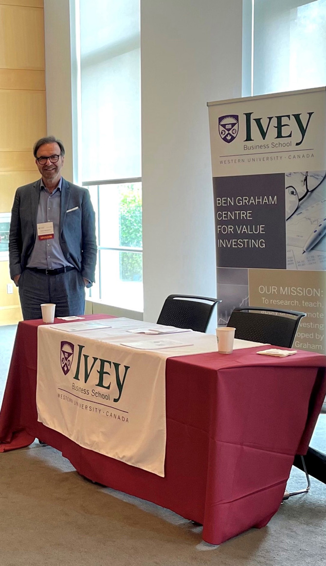 George Athanassakos standing at the Ben Graham Centre's Booth at the CFA New York's Conference