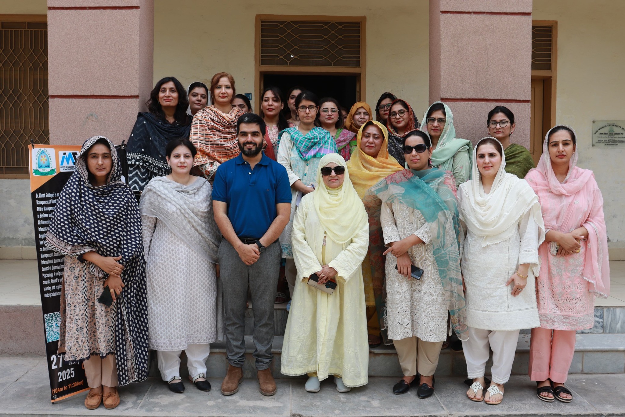 Professor Siddiquei standing in front of Women University Multan with the attendees in a group photo